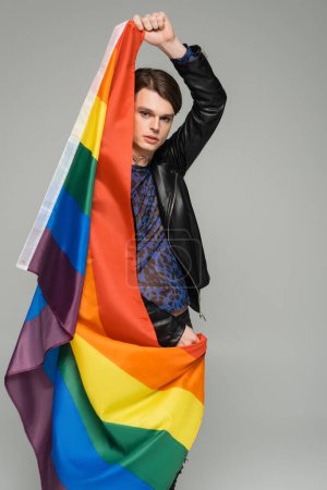 young and fashionable pansexual model posing with lgbt flag isolated on grey