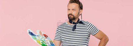 Téléchargez les photos : Artiste français coûteux avec écharpe cou tenant palette avec des peintures colorées isolées sur rose, bannière - en image libre de droit