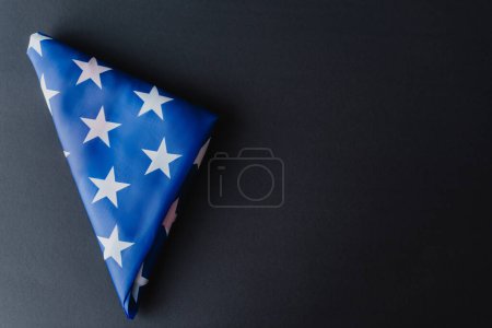 vue du dessus du drapeau plié des États-Unis en forme de triangle isolé sur noir 