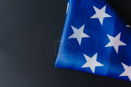 vista superior de la bandera plegada de Estados Unidos en forma de triángulo durante el día conmemorativo aislado en negro 
