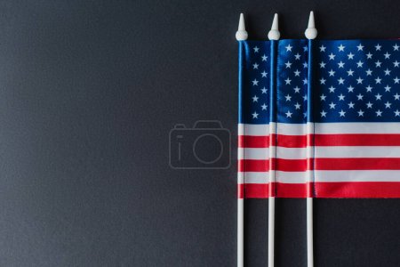 tendido plano de tres banderas de América con estrellas y rayas aisladas en negro 