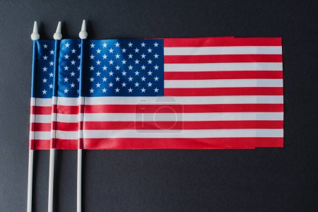 tendido plano de tres banderas americanas con estrellas y rayas aisladas en negro 