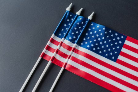 Téléchargez les photos : Vue de dessus des drapeaux américains avec des étoiles et des rayures pour le jour commémoratif isolé sur noir - en image libre de droit