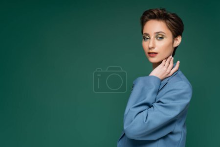 Photo for Charming young woman with short hair posing in blue suit on turquoise green background - Royalty Free Image