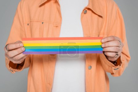 Ausgeschnittene Ansicht eines schwulen Mannes mit lgbt-Fahne isoliert auf grau  