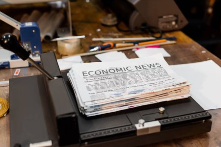 Zeitungen mit Wirtschaftsnachrichten im Inneren des professionellen Papierschneiders