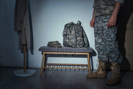 Téléchargez les photos : Vue en coupe du vétéran militaire debout dans le couloir à la maison la nuit - en image libre de droit