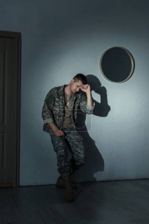 Depressed military veteran suffering from from post traumatic stress disorder at home at night 