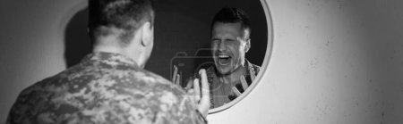 Foto en blanco y negro del soldado estresado con angustia emocional gritando cerca del espejo en casa, pancarta 