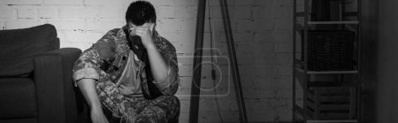 Photo en noir et blanc d'un vétéran militaire souffrant de détresse émotionnelle à la maison, bannière 
