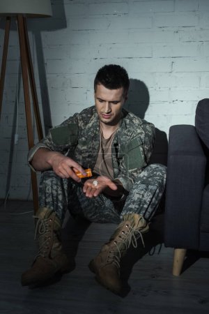 Téléchargez les photos : Vétéran militaire souffrant de maladie mentale qui prend des médicaments à la maison la nuit - en image libre de droit