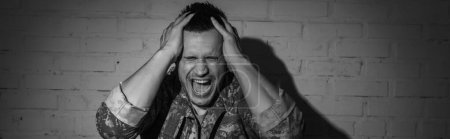 Foto en blanco y negro de veterano militar estresado gritando mientras sufría de trastorno de estrés postraumático en casa, pancarta 