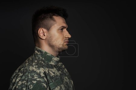 Photo for Profile of sad serviceman in military uniform isolated on black - Royalty Free Image
