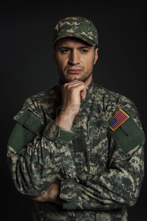 Soldat américain en uniforme de camouflage et casquette souffrant de ptsd isolé sur noir 