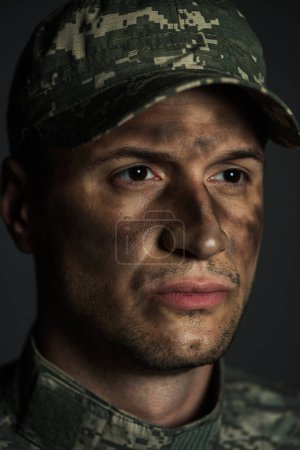close up of with dirt on face suffering from ptsd isolated on grey 
