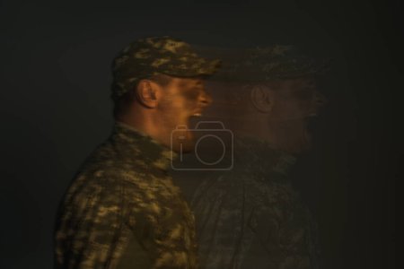 Téléchargez les photos : Longue exposition du soldat souffrant de trouble dissociatif de l'identité et criant isolé sur noir - en image libre de droit