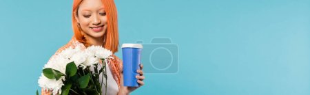 spring vibes, happy asian and young woman with red hair holding paper cup and bouquet of flowers on blue background, casual attire, generation z, coffee culture, coffee to go, banner 