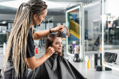 beauty profession, hairdo, hairdresser with braids brushing and separating strands of short brunette hair of woman, haircut, professional, beauty salon work, haircut, hairdressing cape  mug #660916918