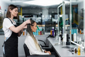 hairdresser and female client, beauty salon, tattooed hair stylist doing hair of woman with braids, two ponytails, customer satisfaction, beauty worker, professional, hair fashion, side view  puzzle #660917872