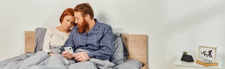 digital couple, screen time, networking, relaxing on weekends without kids, sad husband and wife, bearded man and redhead woman using smartphone, day off, tattooed couple, interior, banner 