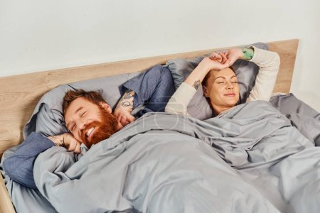 quiet house, parents alone at home, redhead husband and wife in cozy bedroom, bearded man and carefree woman relaxing on weekends, day off, wake up, tattooed, closed eyes 