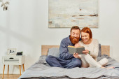 quality time, reading book together, happiness, day off without kids, redhead husband and wife, bonding, happiness, bearded man and woman, relaxation, parents alone at home, lifestyle, adult leisure  Stickers #661667254