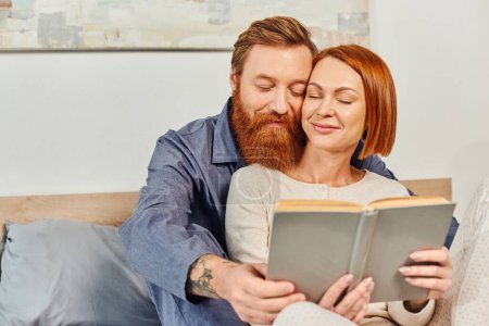 quality time, reading book together, happiness, day off without kids, redhead husband and wife, bonding, pleased, bearded man and woman, relaxation, parents alone at home, lifestyle, adult leisure 
