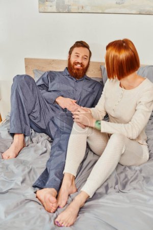 Photo for Quality time, day off without kids, redhead husband and wife, bearded man and woman holding hands of each other, cheerful parents alone at home, modern lifestyle, relationship - Royalty Free Image