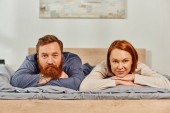 day off without kids, happy couple relaxing together, lying on bed, redhead husband and wife, enjoying time together,  bearded man and carefree woman looking at camera, tattooed people  magic mug #661667622