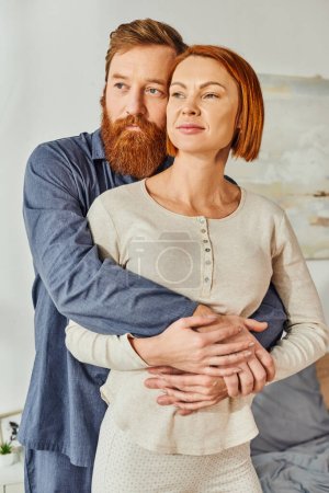 married couple hugging in cozy bedroom, day off without kids, redhead husband and wife, enjoying time together, weekends together, tattooed, bonding, love, parents alone at home