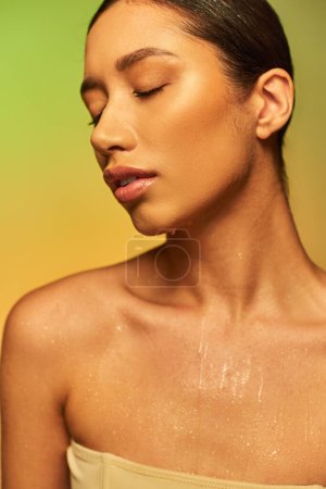 Flüssigkeitszufuhr, junge asiatische Frau mit nackten Schultern und nassem Körper posiert auf einem grünen Hintergrund, geschlossenen Augen, Hautpflege-Kampagne, Schönheitsmodel, brünettes Haar, glühende Haut 