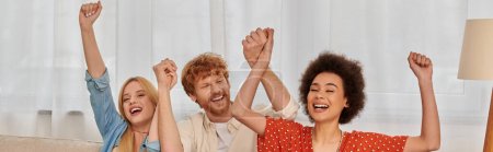 polyamorous relationship, cultural diversity, redhead man raising hands with multiracial female lovers, positivity, freedom and acceptance, love triangle, people in open relationship, banner 