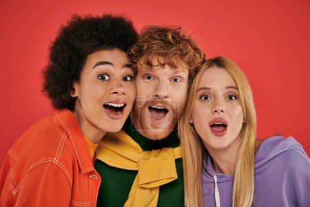 polyamorous concept, portrait of young man and multicultural women on coral background, studio shot, vibrant colors, love triangle, bonding and acceptance, excited polygamy lovers 