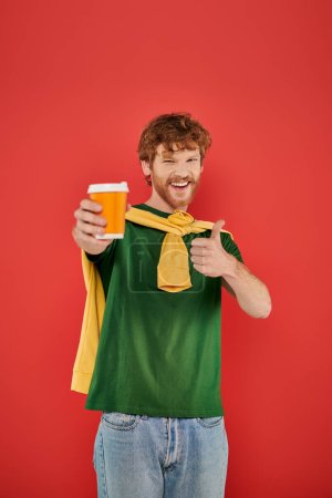 morning coffee, energy, like, redhead man with beard and curly hair holding paper cup on coral background, vibrant colors, male fashion, takeaway drink, male portrait, hot beverage