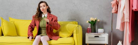 concept photography, posing like a doll, young woman with wavy hair sitting on yellow couch, gesturing, stylish house interior, vase with tulips, looking at camera, housewife lifestyle, banner