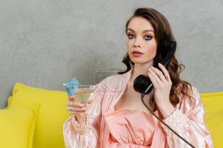 emotional stress, sad woman with smudged mascara sitting on yellow couch, housewife with crying eyes talking on retro phone, holding cocktail, feeling lonely and depressed, heartbroken wife at home 