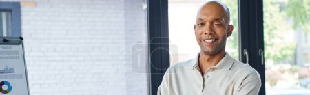 professional headshots, happy african american businessman with eye syndrome looking at camera and standing with folded arms, myasthenia gravis, dark skinned and bold office worker, banner 