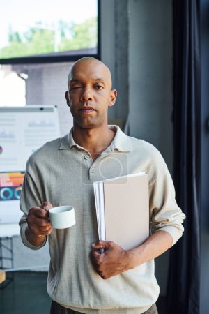 african american man with myasthenia gravis disease holding folder and cup of coffee, bold and dark skinned office worker with ptosis eye syndrome, inclusion, professional headshots 