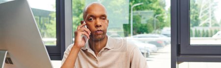 myasthenia disease, bold african american man at work, dark skinned office worker with ptosis syndrome talking on smartphone, inclusion, corporate culture, monitor, banner 