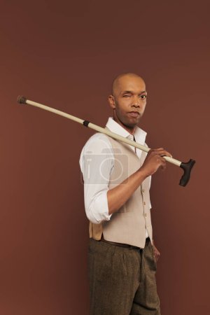 inclusion, myasthenia gravis syndrome, bold african american man holding walking stick, looking at camera, dark skinned, real people, neurological disorder, physical impairment 