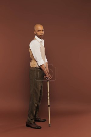 Photo for Inclusion, myasthenia gravis syndrome, bold african american man standing with walking stick, looking at camera, dark skinned, real people, neurological disorder, physical impairment, full length - Royalty Free Image