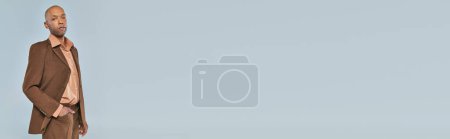 Augensyndrom, fetter afrikanisch-amerikanischer Mann mit Myasthenia gravis, der mit der Hand in der Tasche auf grauem Hintergrund steht, dunkelhäutige Person in formeller Kleidung, Vielfalt und Inklusion, echte Menschen, Banner 