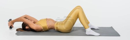 deportista en desgaste activo amarillo y calcetines haciendo ejercicio con mancuernas, fondo blanco