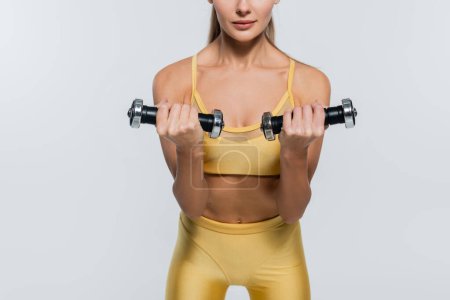 cropped, active lifestyle, sportswoman exercising with dumbbells, white background, active wear