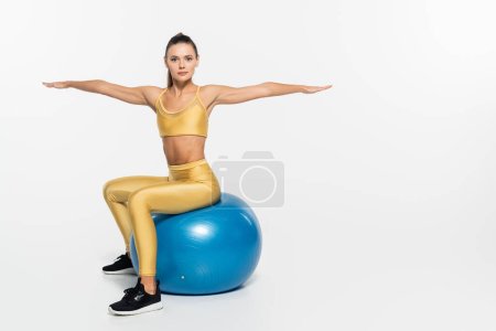 mode de vie sain, aérobic, femme en tenue active travaillant sur balle de fitness, fond blanc