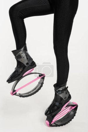 partial view of woman in jumping boots on white background, kangoo jumping shoes 