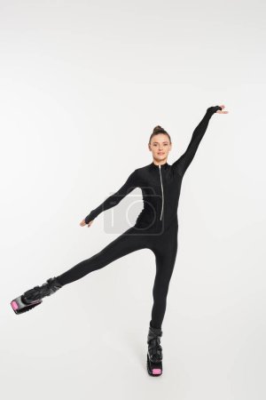 jumping boots, white background, sportswoman in black jumpsuit and kangoo jumping shoes 