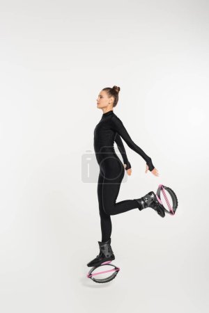 Training und Kraft, Frau in Kangoo-Springschuhen, die auf weißem Hintergrund trainieren, Springerstiefel 