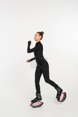 energy and strength, woman in kangoo jumping shoes exercising on white background, jumping boots 