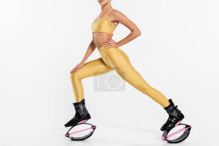 jumping boots, active lifestyle, cropped view of woman in kangoo jumping shoes on white background Poster 664865812